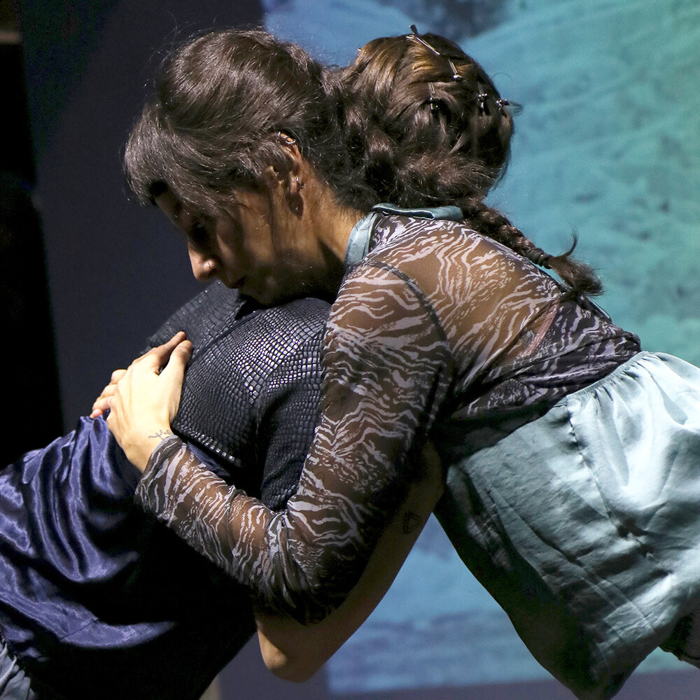 2 Performer lehnen sich frontal gegeneinander und halten sich im Arm