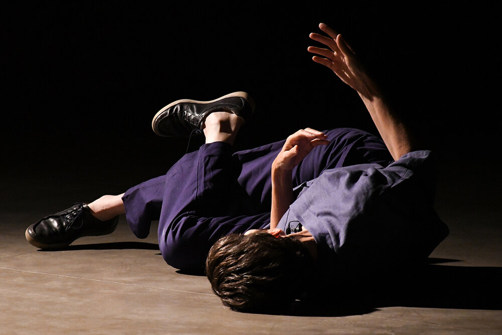 Eine Person auf dem Boden bewegt Hand und Fuß sanft im Raum